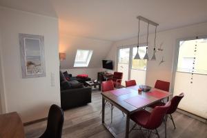 a dining room and living room with a table and chairs at Ostseeblick-Laue-Wohnung-8-H in Hohwacht