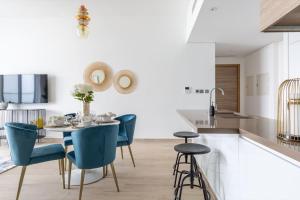 a kitchen with a table and blue chairs at Frank Porter - Studio One in Dubai
