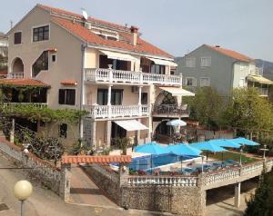 un gran edificio con sombrillas y una piscina en Apartments Villa Vera, en Novi Vinodolski