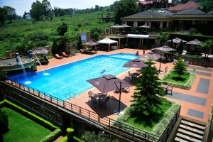 an overhead view of a large swimming pool with umbrellas at Nobleza Hotel in Kigali