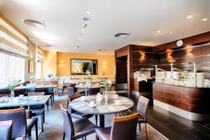 a restaurant with tables and chairs and a counter at ACHAT Hotel Wiesbaden City in Wiesbaden