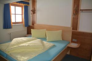 - une chambre avec un lit doté d'un matelas bleu et d'une fenêtre dans l'établissement Haus Höring, à Dienten am Hochkönig