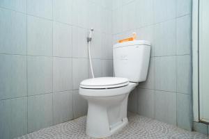 a bathroom with a white toilet in a room at Sitiinggil Syariah RedPartner in Tegal +62 photos