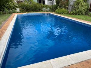 una piscina con acqua blu in un cortile di Leo Guest House a Robertson