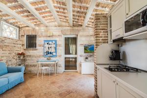 eine Küche mit einem blauen Sofa und einem Tisch in der Unterkunft Il Casale Di Giulia in Sirolo