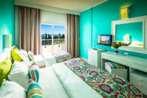 a hotel room with two beds and a television at Splash World Venus Beach in Hammamet