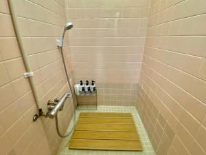 a shower with a wooden floor in a bathroom at Gunjonoma Yadokari in Okayama