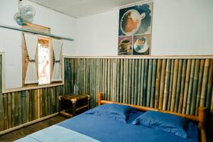 una camera da letto con pareti in bambù, un letto e uno sgabello. di Backpacker Kawah Ijen a Banyuwangi