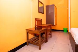 a room with a wooden table and a chair in it at Sitiinggil Syariah RedPartner in Tegal