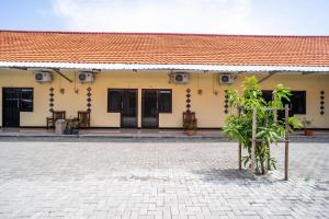 a building with a red roof and a courtyard at KoolKost Syariah near Transmart Tegal in Tegal