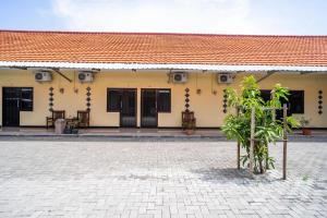 a building with a red roof and a courtyard at Sitiinggil Syariah RedPartner in Tegal