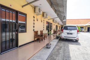 una furgoneta blanca estacionada al lado de un edificio en KoolKost Syariah near Transmart Tegal en Tegal