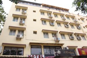 a building with windows and a sign in front of it at Hotel The New SG in Ahmedabad