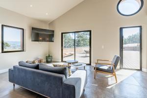 ein Wohnzimmer mit einem Sofa und einem TV in der Unterkunft Loft d'architecte au coeur d'un domaine viticole in La Cadière-dʼAzur