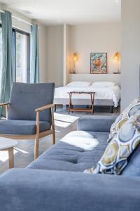 - un salon avec des canapés bleus et un lit dans l'établissement Loft d'architecte au coeur d'un domaine viticole, à La Cadière-dʼAzur