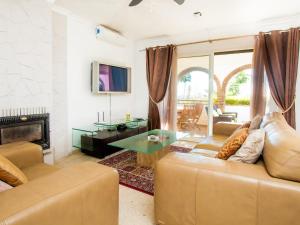 een woonkamer met een bank en een tafel bij Villa Las Granadillas by Interhome in Estepona