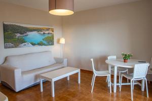 een woonkamer met een bank en een tafel bij Siesta Mar Apartamentos in Cala'n Porter