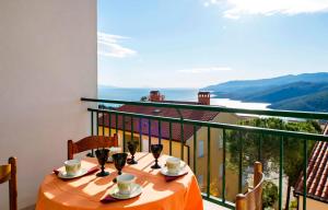 einen Tisch mit Tassen und Untertassen auf einem Balkon in der Unterkunft Apartments Eugen 2024 in Rabac
