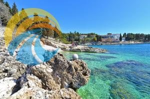 Blick auf einen Strand mit blauem Wasser und Fallschirm in der Unterkunft Apartments Eugen 2024 in Rabac