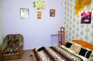 a bedroom with a bed and a chair and a wall at Успенский in Odesa