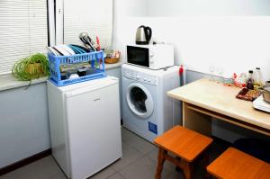a kitchen with a washing machine and a microwave at Успенский in Odesa