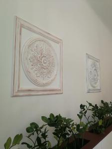 two framed pictures on a white wall with plants at TulipánVendégház in Keszthely