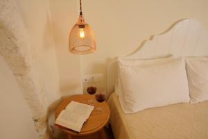 a bedroom with a bed and a table with a book at Veranda Rossa Suites in Rethymno Town