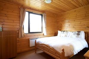 a bedroom with a bed in a log cabin at Concraig Lodge in Crieff