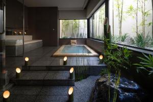 a bathroom with a tub and a swimming pool at THE JUNEI HOTEL Kyoto in Kyoto