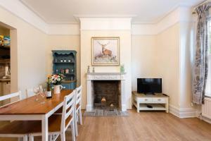 une salle à manger avec une table et une cheminée dans l'établissement Bikki Apartments - 2 Bedroom, à Harrow