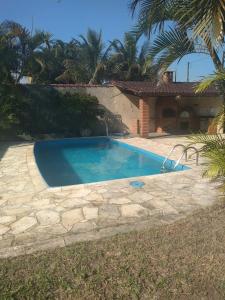 una piscina en un patio junto a una casa en Casa na Praia c/Piscina e Churrasqueira, en Itanhaém