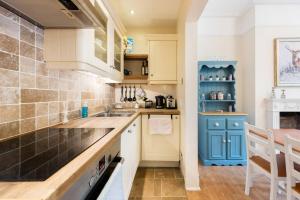 uma cozinha com armários azuis e brancos e um balcão em Bikki Apartments - 2 Bedroom self contained em Harrow mais 17 fotografias