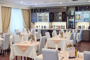 een eetkamer met witte tafels en witte stoelen bij Hotel Pushkin in Oral