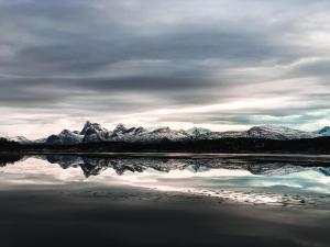 a mountain range with its reflection in the water at Tysfjord Hotel in Storjord I Tysfjord