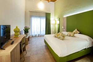 una camera d'albergo con letto e TV di Eco Resort Dei Siriti a Nova Siri