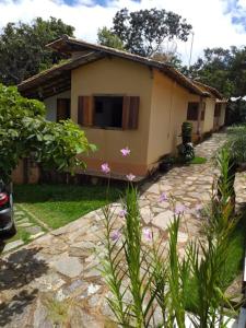 a small house with a stone path in front of it at CHALÉS MUCIOS in Serra do Cipo