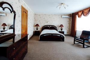 a bedroom with a bed and a dresser and a mirror at Spasskaya Hotel in Vologda