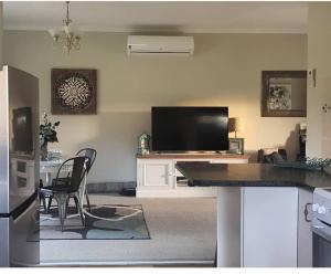 a living room with a tv and a table and chairs at Little Britton in Wingham