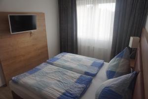 Schlafzimmer mit einem Bett und einem TV an der Wand in der Unterkunft Ferienwohnung Gipfelstürmer Feldberg - Ski in Ski out, Whirlpool & Infrarotkabine in Feldberg