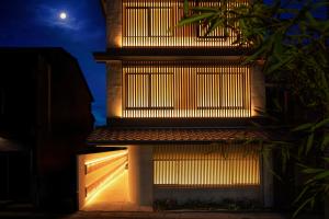 a building with lights on the side at night at THE JUNEI HOTEL Kyoto in Kyoto