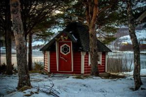 a red cabin with a red door in the snow at Tysfjord Hotel in Storjord I Tysfjord