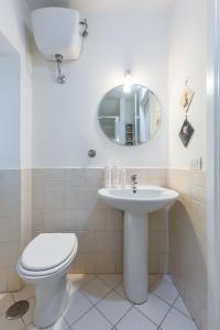 y baño con aseo, lavabo y espejo. en Appartamento a Piazza Cavour by Wonderful Italy, en Nápoles