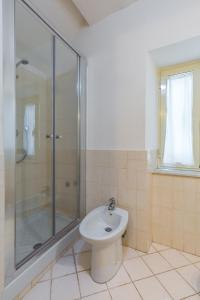 een badkamer met een douche, een toilet en een wastafel bij Appartamento a Piazza Cavour by Wonderful Italy in Napels