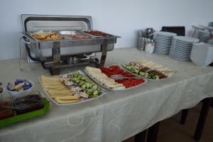 una mesa con varios platos de comida. en Pensiunea Eden, en Ranca