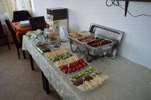 une table contenant de nombreux types de denrées alimentaires différents dans l'établissement Pensiunea Eden, à Rânca