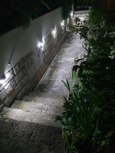 a stone walkway with lights on the side of a building at Apartments Dub in Dubrovnik +19 photos