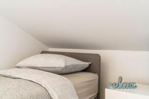 a bed with two pillows on it in a bedroom at Apartments Šmanjak in Cavtat