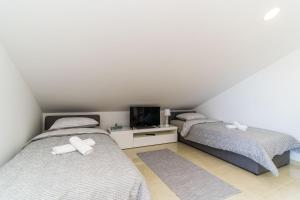 Cette chambre comprend 2 lits jumeaux et une télévision. dans l'établissement Apartments Šmanjak, à Cavtat