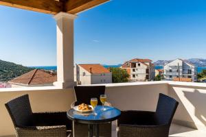 a balcony with a table and two glasses of wine at Apartments Šmanjak in Cavtat
