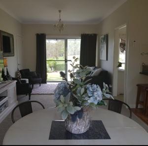 a living room with a vase of flowers on a table at Little Britton in Wingham